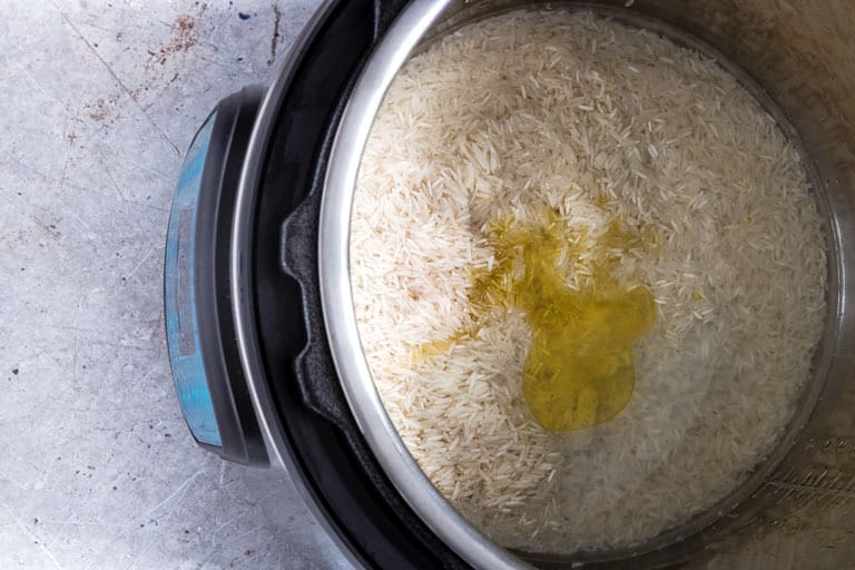 overhead view of top of instant pot containing raw instant pot rice ingredients