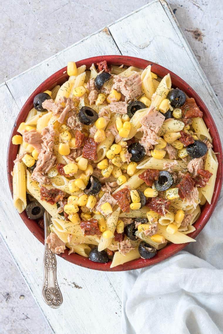 tuna pasta salad served in a red bowl with spoon