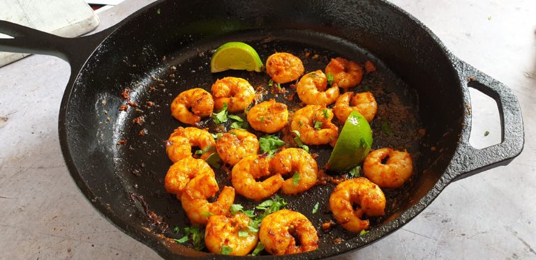 blackened shrimp cooking in a cast iron skillet