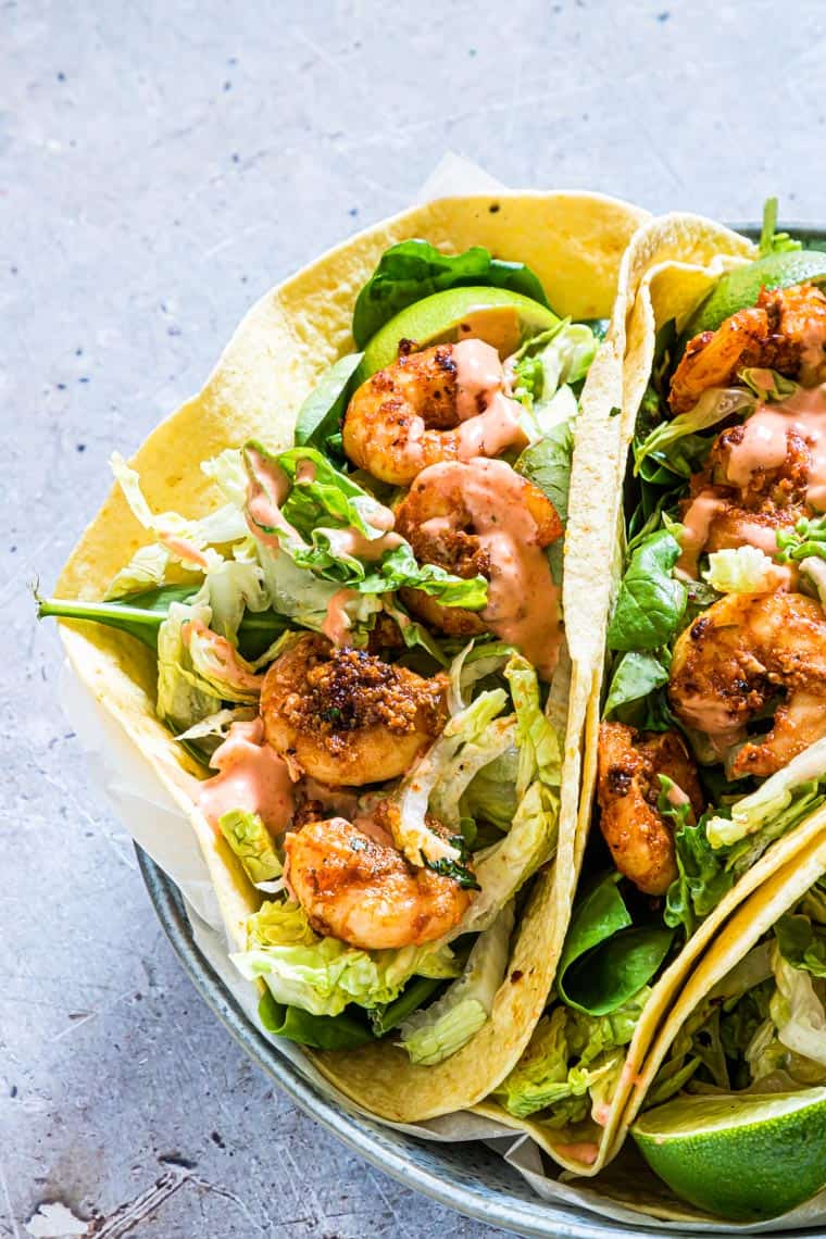 a plate filled with shrimp tacos