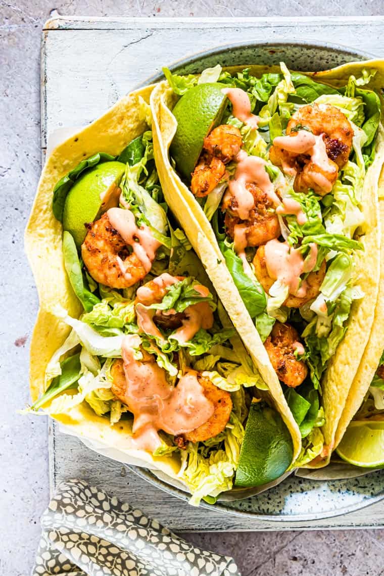 three shrimp tacos served on a plate