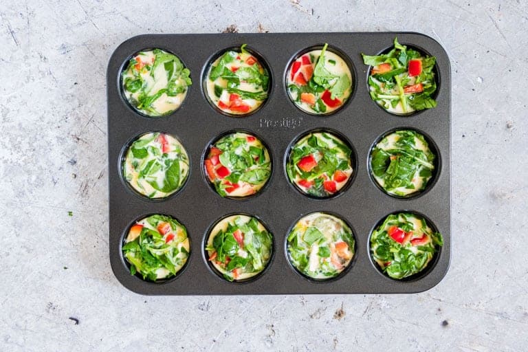 overhead view of egg bites batter in a muffin tin