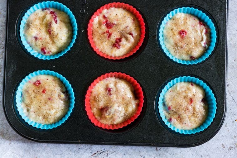raspberry muffin batter in a muffin tin