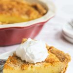 a slice of Bourbon Buttermilk Pie topped with whipped cream