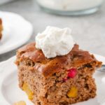 one serving of fruit cocktail cake topped with whipped cream