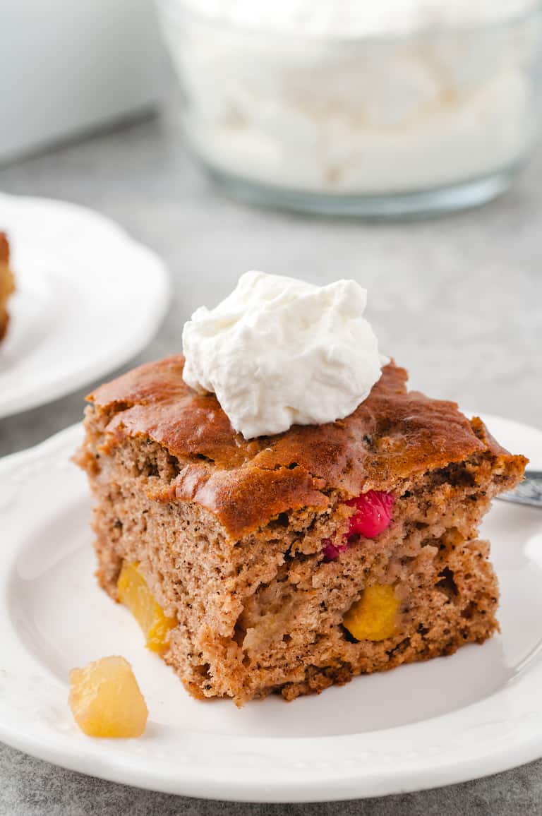 one serving of fruit cocktail cake topped with whipped cream