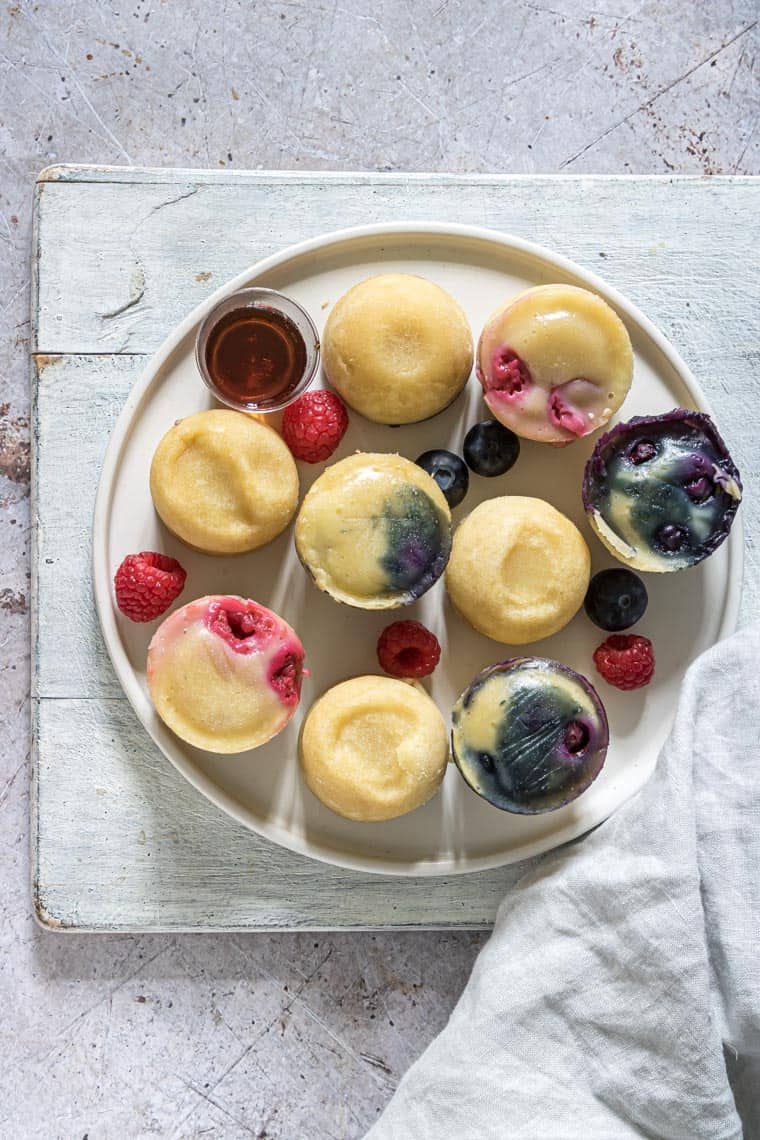 instant pot pancake bites served on a white plate with syrup and fresh fruit