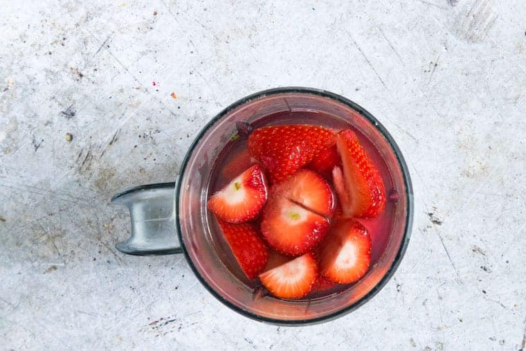 strawberries in a blender to make a margarita