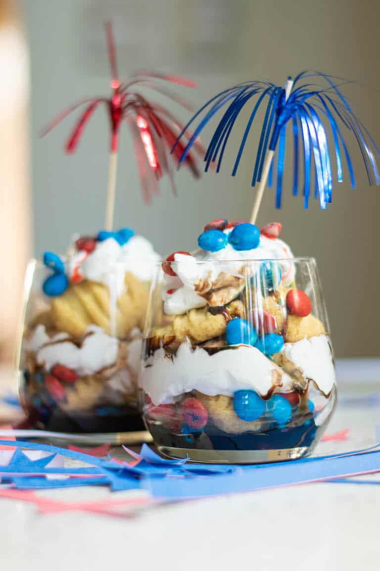 red white and blue trifle served in glass jars with colorful decorations