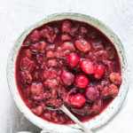 instant pot cranberry sauce served in a ceramic bowl with spoon and cloth napkin