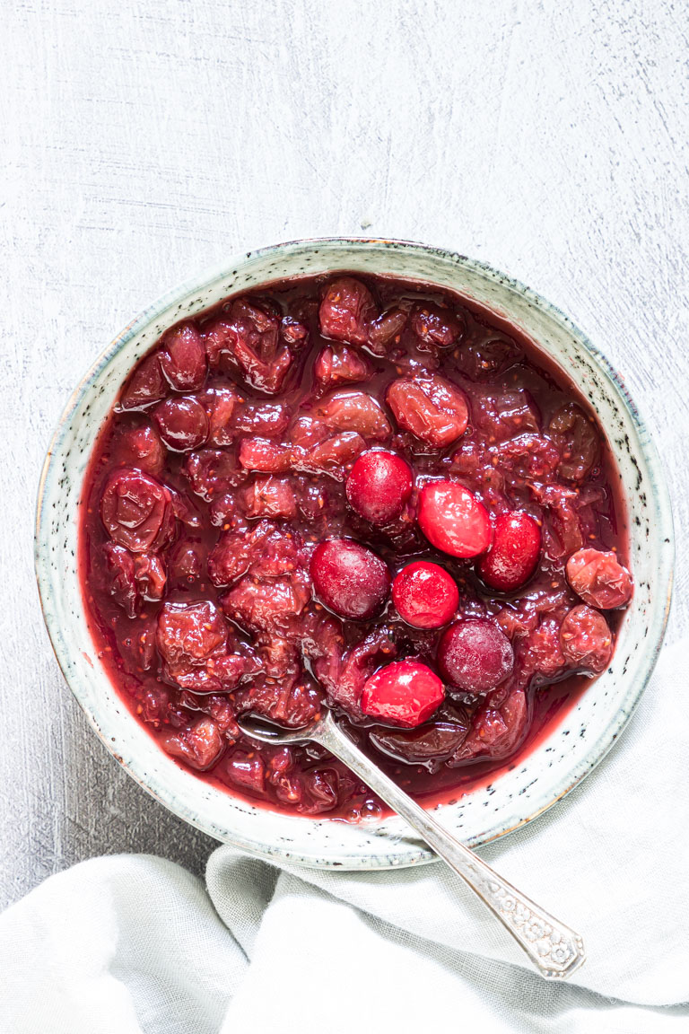 instant pot cranberry sauce served in a ceramic bowl with spoon and cloth napkin