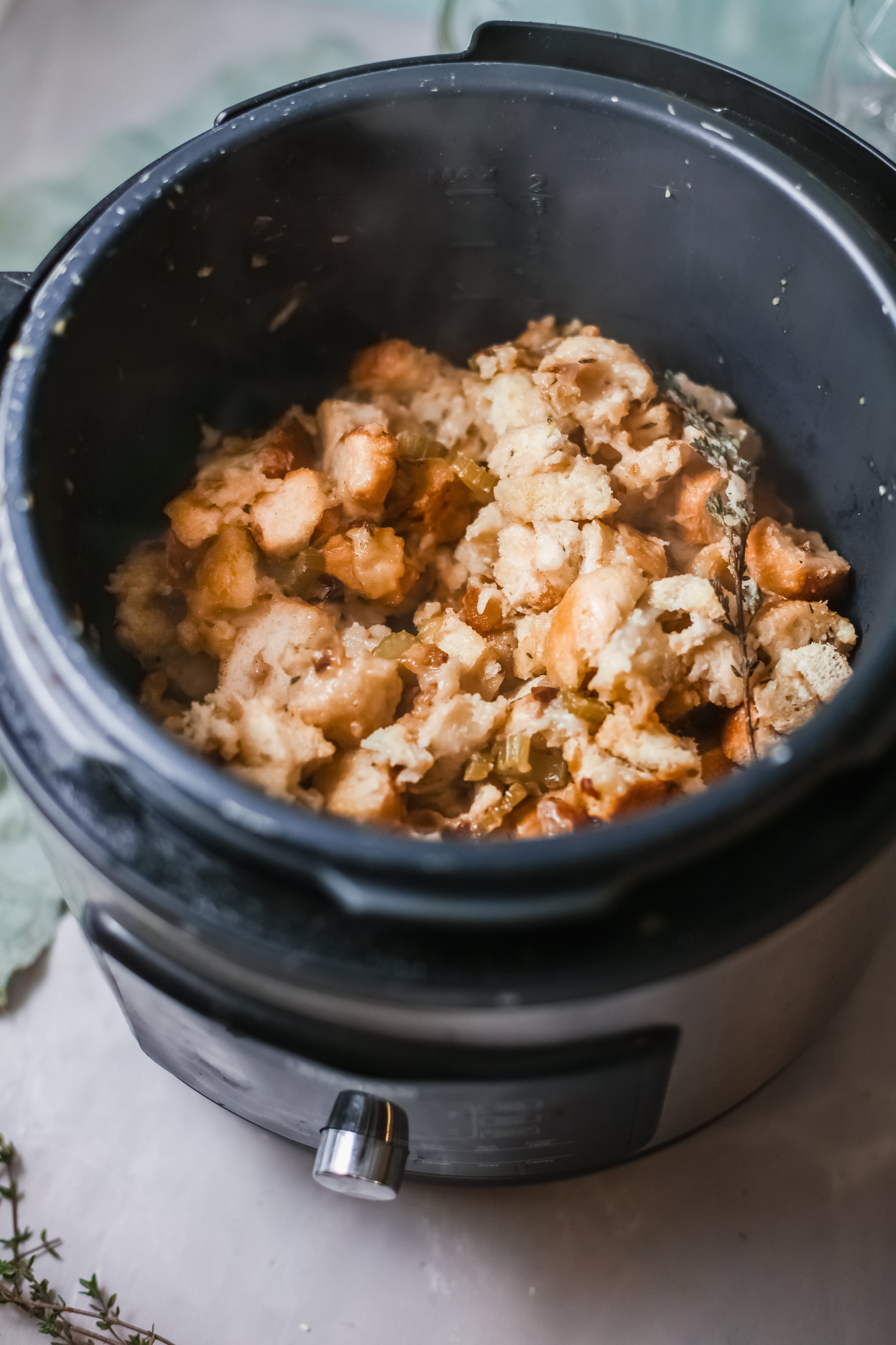 cooked instant pot stuffing inside the instant pot with herb garnish