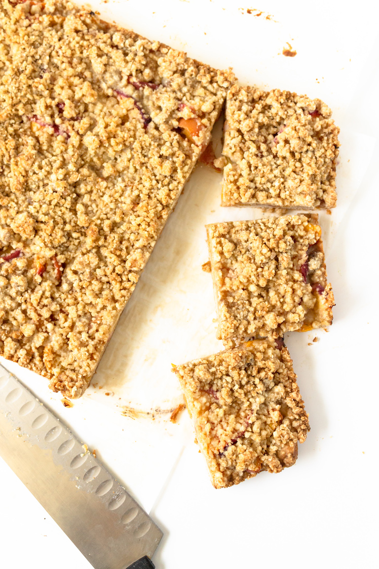 top down view of the peach crumb bars being sliced into squares