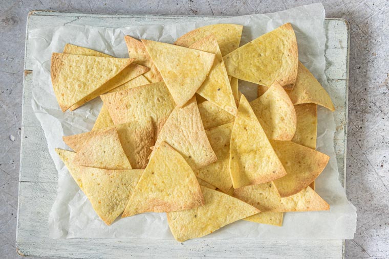 tortilla chips made in the oven on as sheet of parchment paper