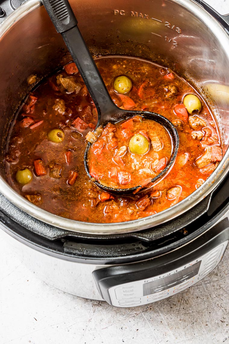 instant pot lamb stew inside the instant pot with a propped in serving spoon