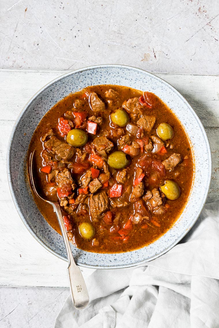 instsnt pot lamb stew served in a blue bowl with a spoon and cloth napkin