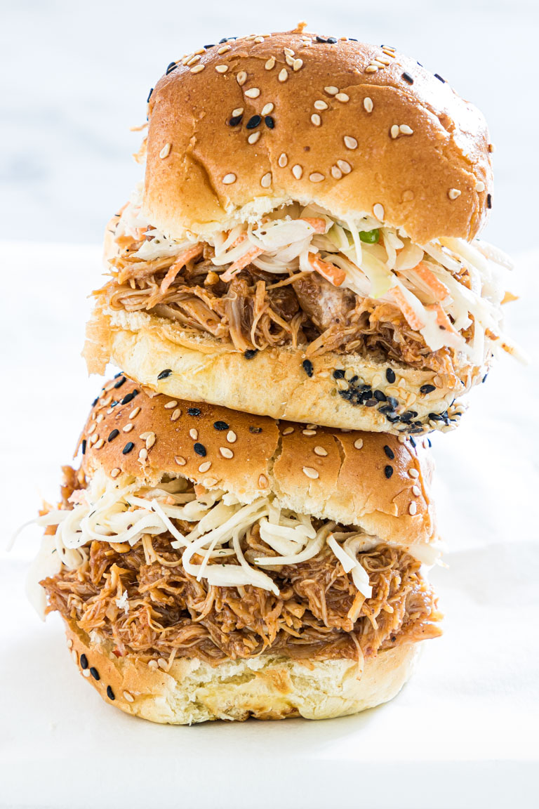 two instant pot pulled chicken sandwiches stacked on one another