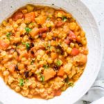 instant pot split pea soup in a white bowl next to a grey towel