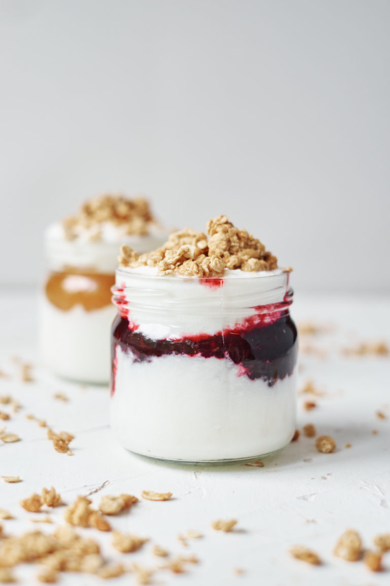 two portions of instant pot yogurt served with jam and granola