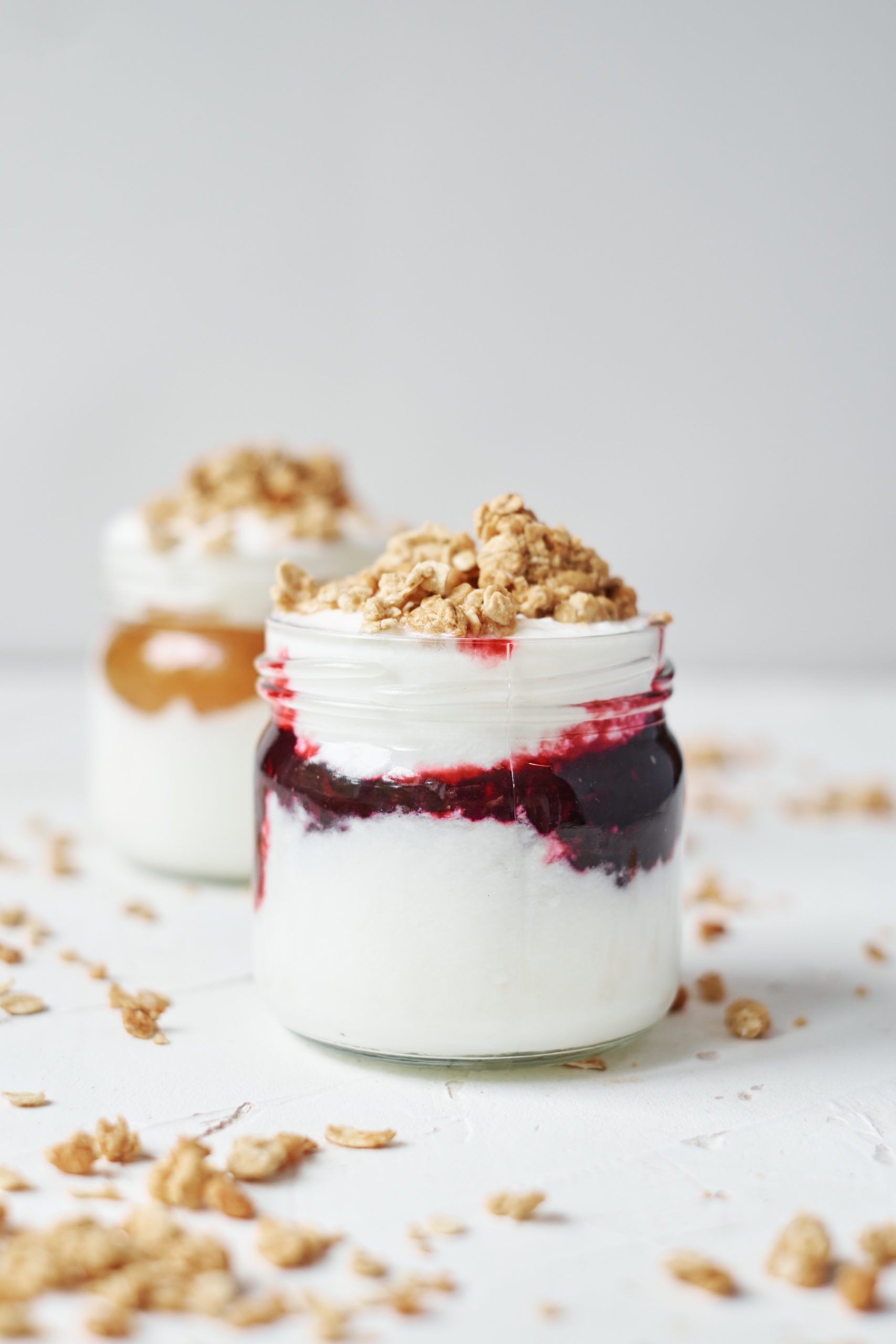 two portions of instant pot yogurt in jars served with jam and granola