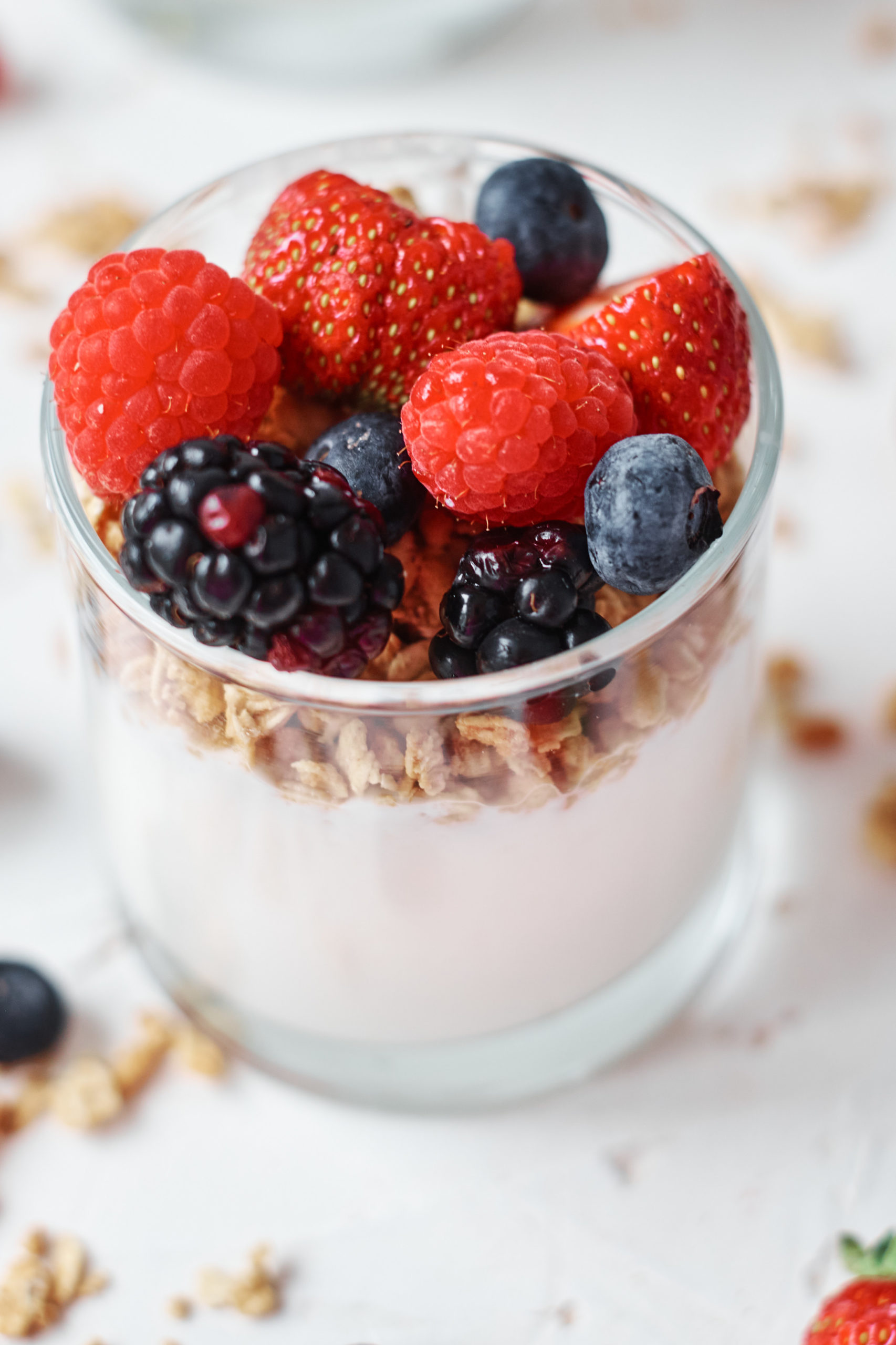 creamy instant pot yogurt served in a glass jar and topped with berries and granola