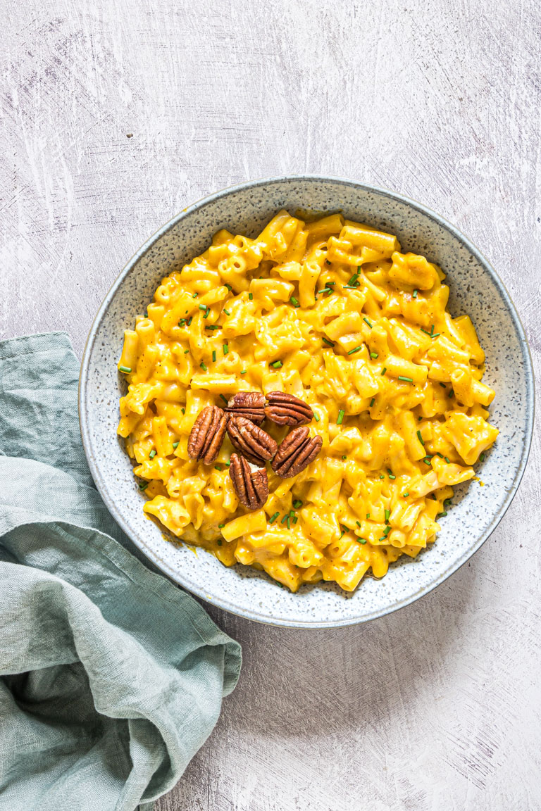 a bowl of instant pot pumpkin mac and cheese topped with toasted pecans