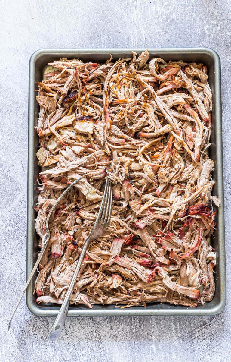 top down view of shredded smoked pork shoulder with two forks