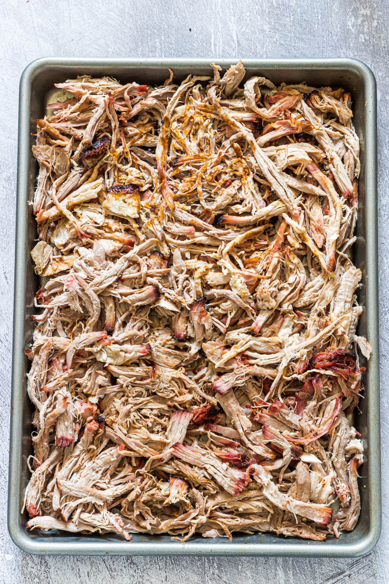 top down view of shredded smoked pork shoulder on a baking tray