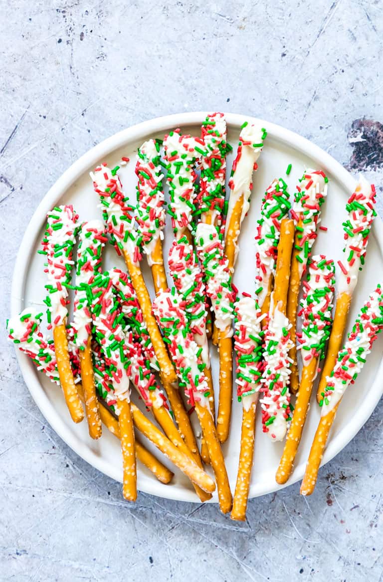 white chocolate dipped pretzels rods on a plate