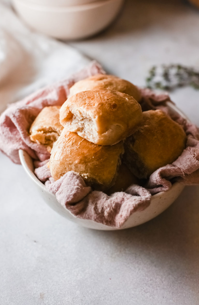 instant pot dinner rolls inside a serving bowl lined with a cloth kitchen towel