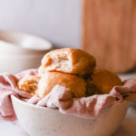 completed instant pot dinner rolls served in a bowl lined with a cloth towel