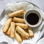close up view of the completed air fryer egg rolls served with soy sauce