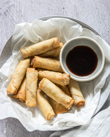 close up view of the completed air fryer egg rolls served with soy sauce