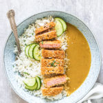 the completed SPAM Fritters Katsu Curry Recipe served in a bowl with rice and cucumber slices