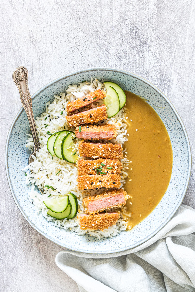 the completed SPAM Fritters Katsu Curry Recipe served in a bowl with rice and cucumber slices