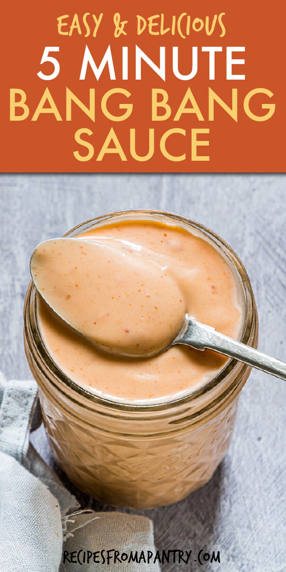 a glass jar of bang bang sauce with a spoon in it