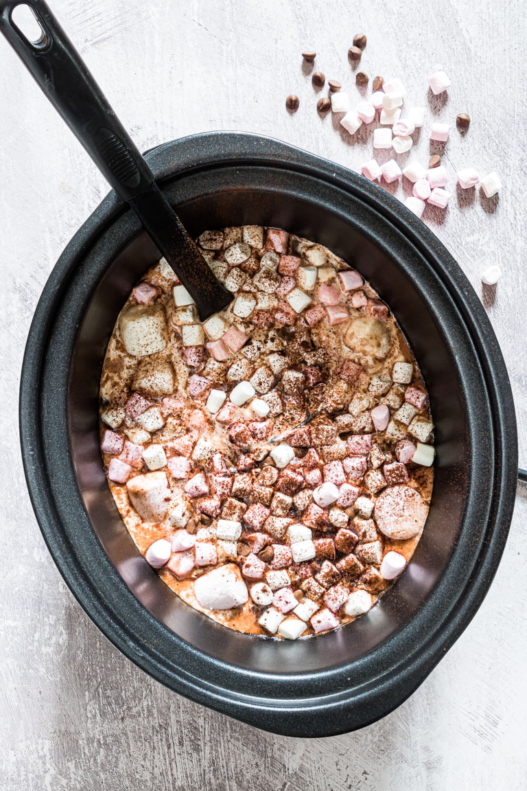 top down view of the finished crock pot hot chocolate inside the crockpot with a ladle