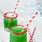 two glasses of Grinch punch served with red striped straws
