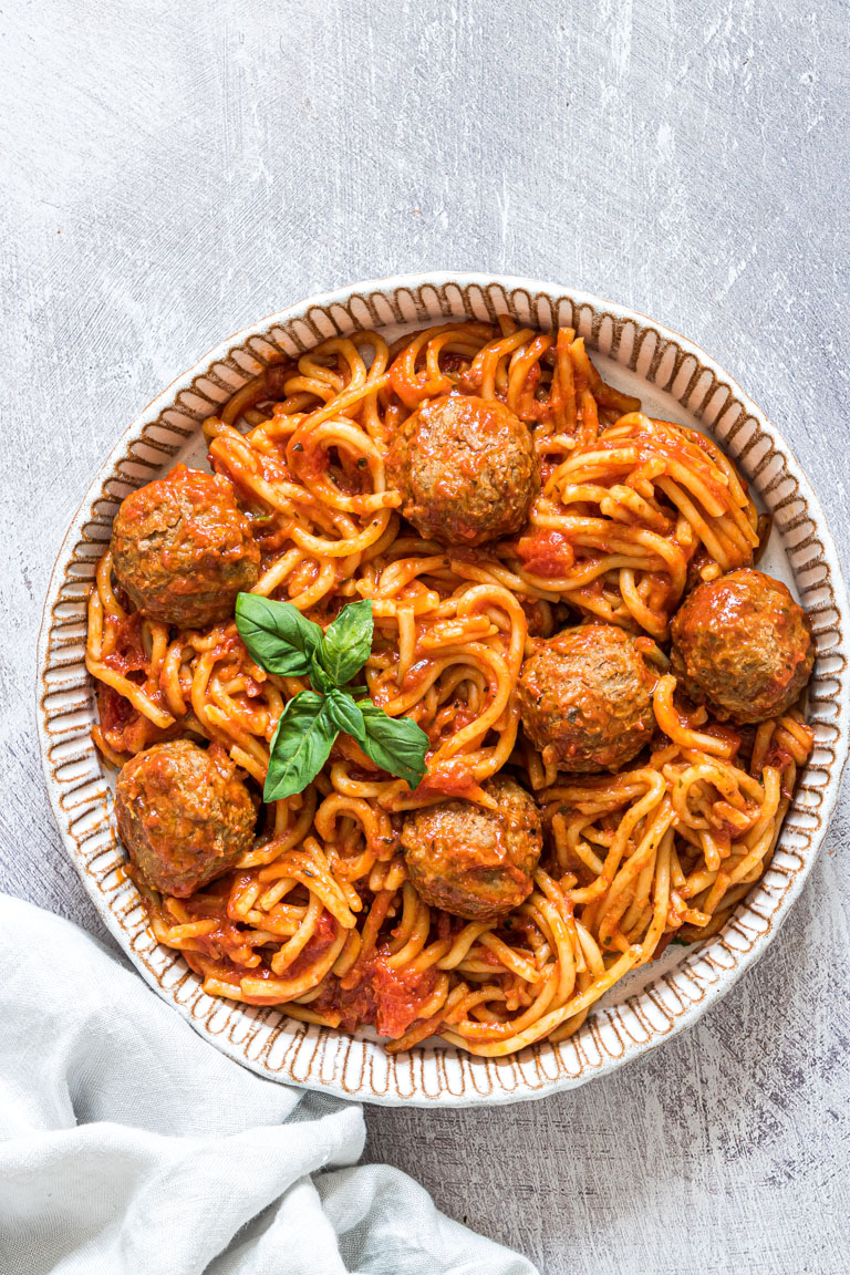 top down view of a round bowl of spaghetti and meatballs