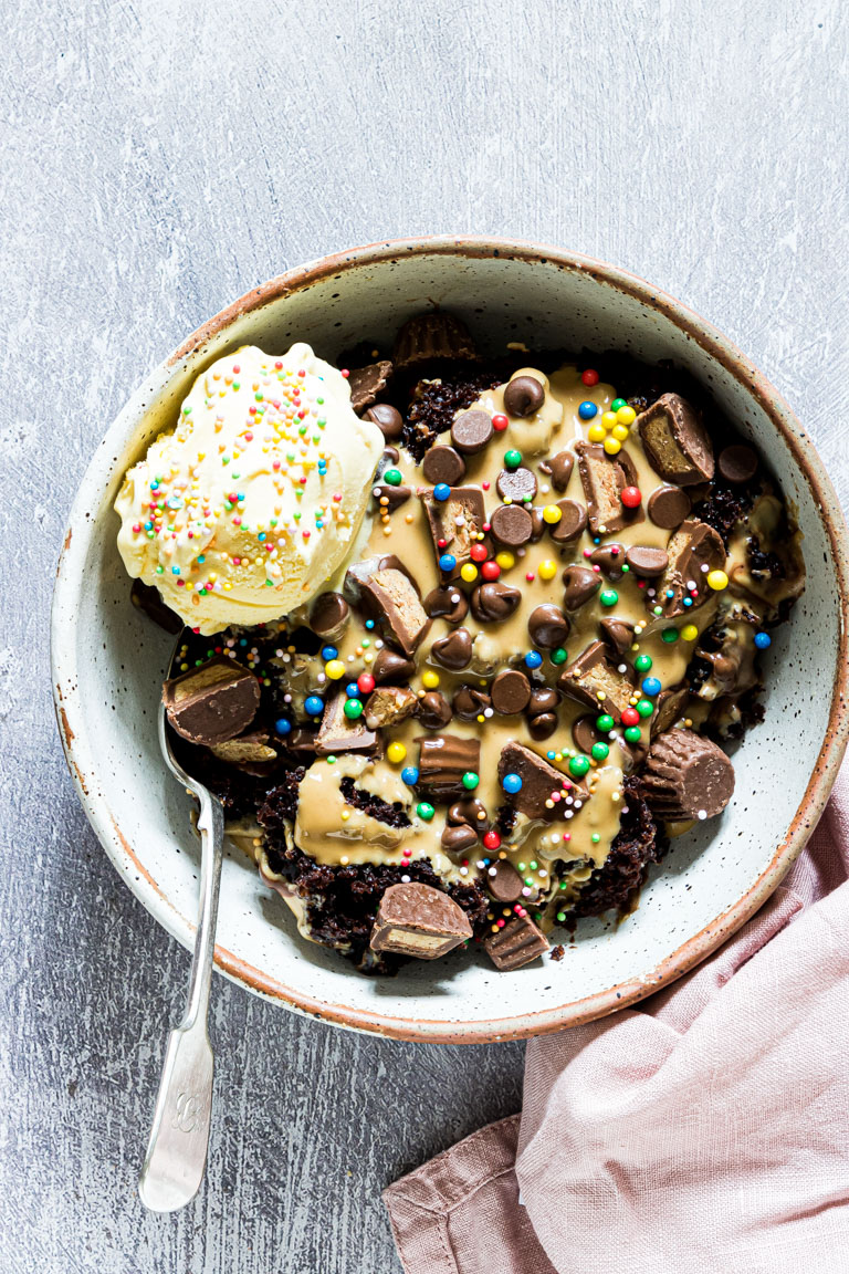 top down view of a serving of the slow cooker chocolate peanut butter cake with ice cream and sprinkles