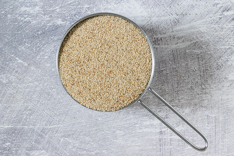 a measuring cup filled with whole grain teff