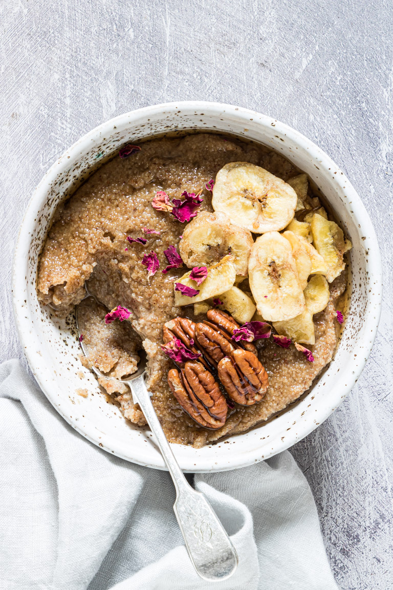 a serving of the teff porridge recipe in a bowl with a spoon inside