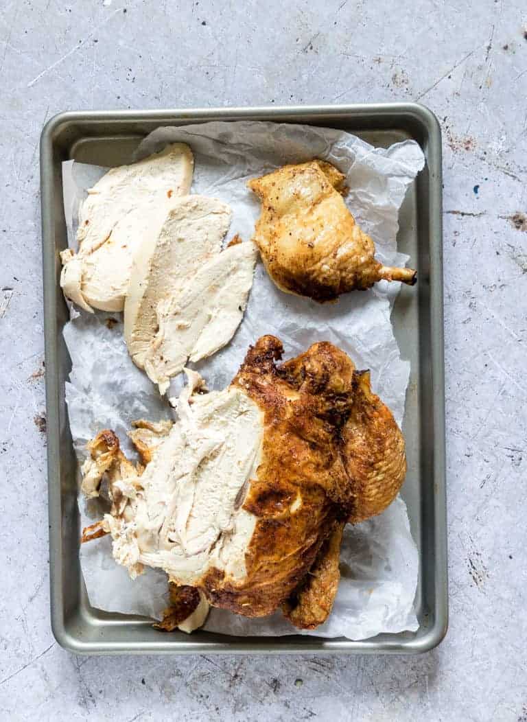 top down view of cooked crispy chicken on a baking tray that has been cut into pieces