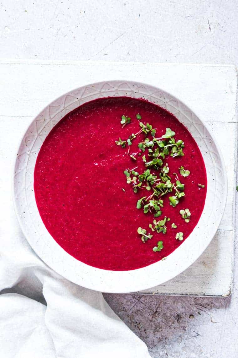 Thai curry beetroot soup ready to serve with a white cloth napkin