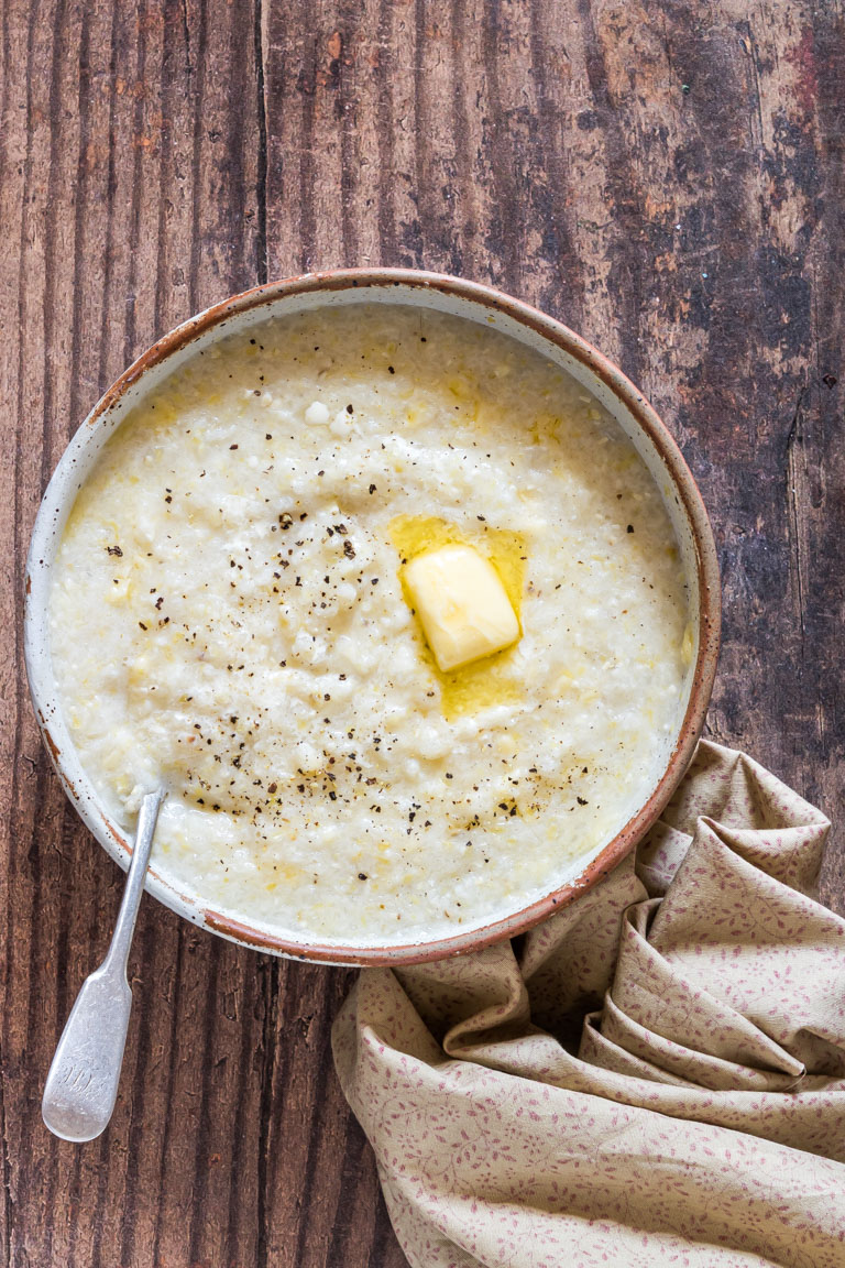 the finished grits recipe in a bowl with a spoon and ready to be served