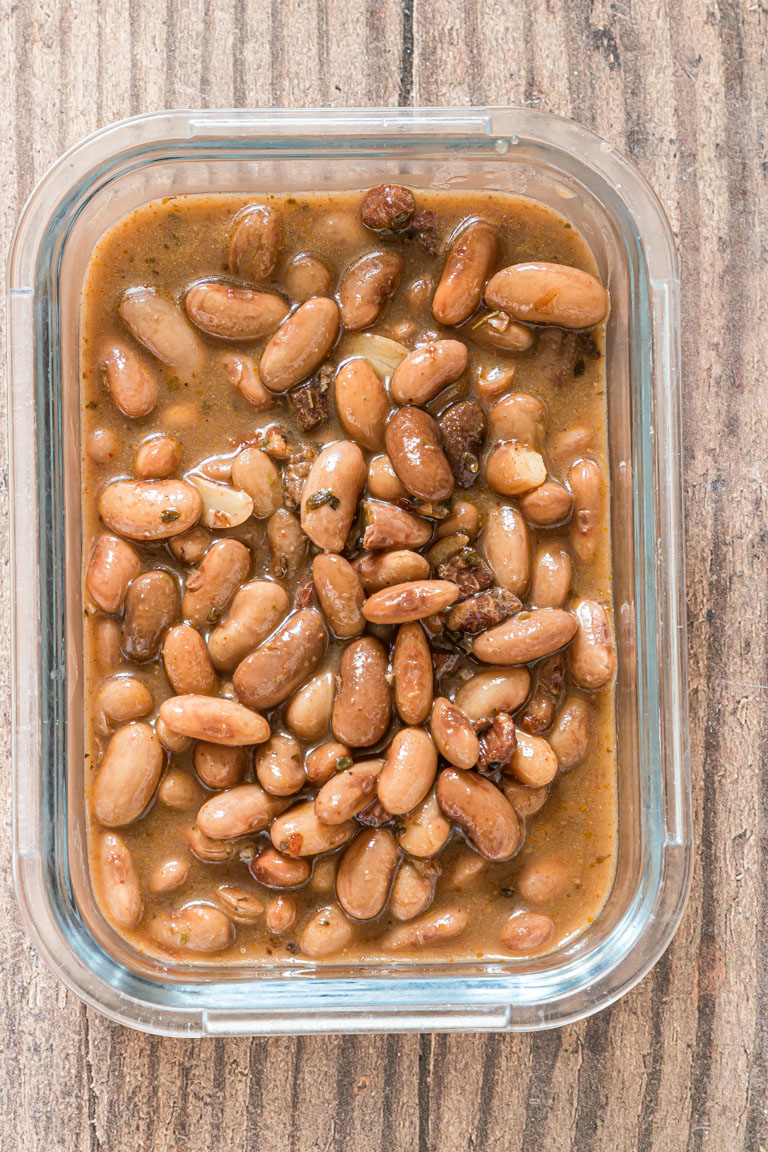 the finished pinto beans inside a glass storage container