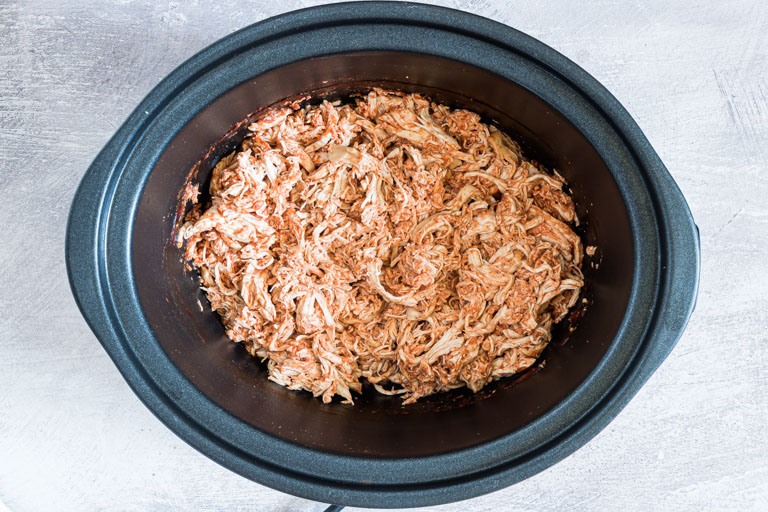 the completed salsa chicken recipe inside the slow cooker insert