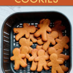Gingerbread man cookies inside an air fryer basket