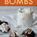 hot chocolate bombs wrapped in cellophane in front of a mug