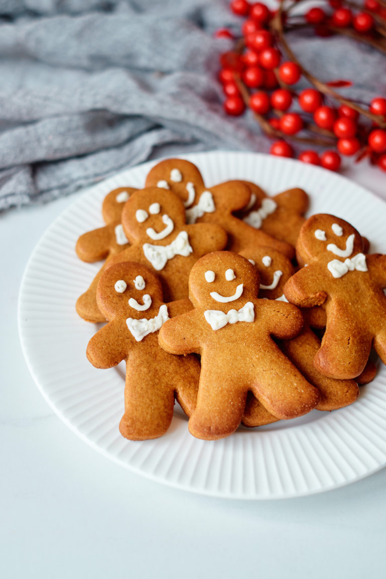 a white plate filled with decorated gingerbread man cookies